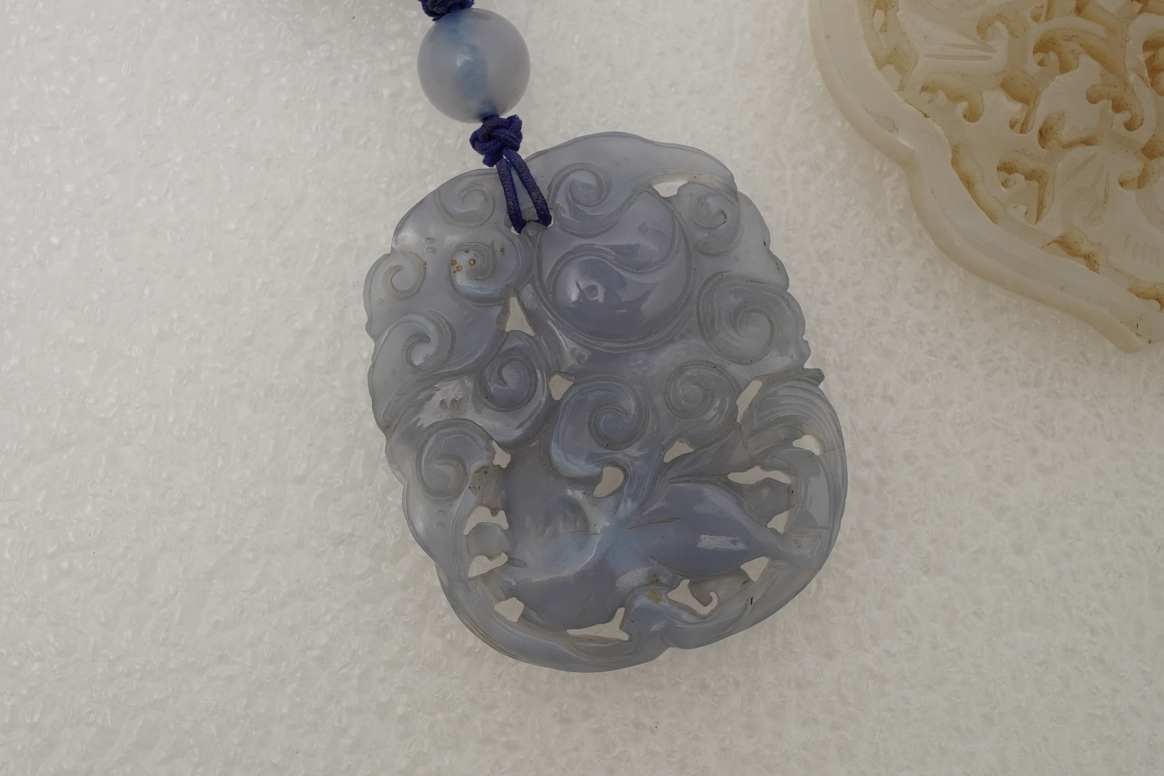 A Chinese jade ‘spirit lock’ plaque, a jadeite bead necklace and a blue quartz bead necklace, 20th century